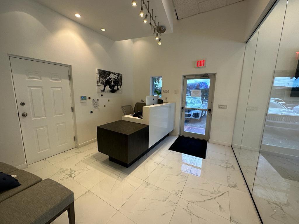 A modern office reception area features a white and dark wood desk on tiled floors — 425 NW 10th Terrace, Hallandale Beach FL 33009, HALLANDALE BEACH, FL