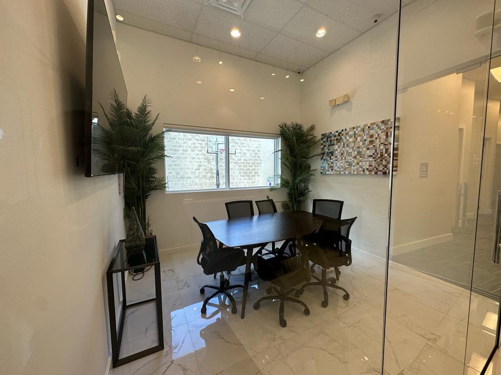 A small conference room features a dark wood table, four chairs, and a wall-mounted television — 425 NW 10th Terrace, Hallandale Beach FL 33009, HALLANDALE BEACH, FL