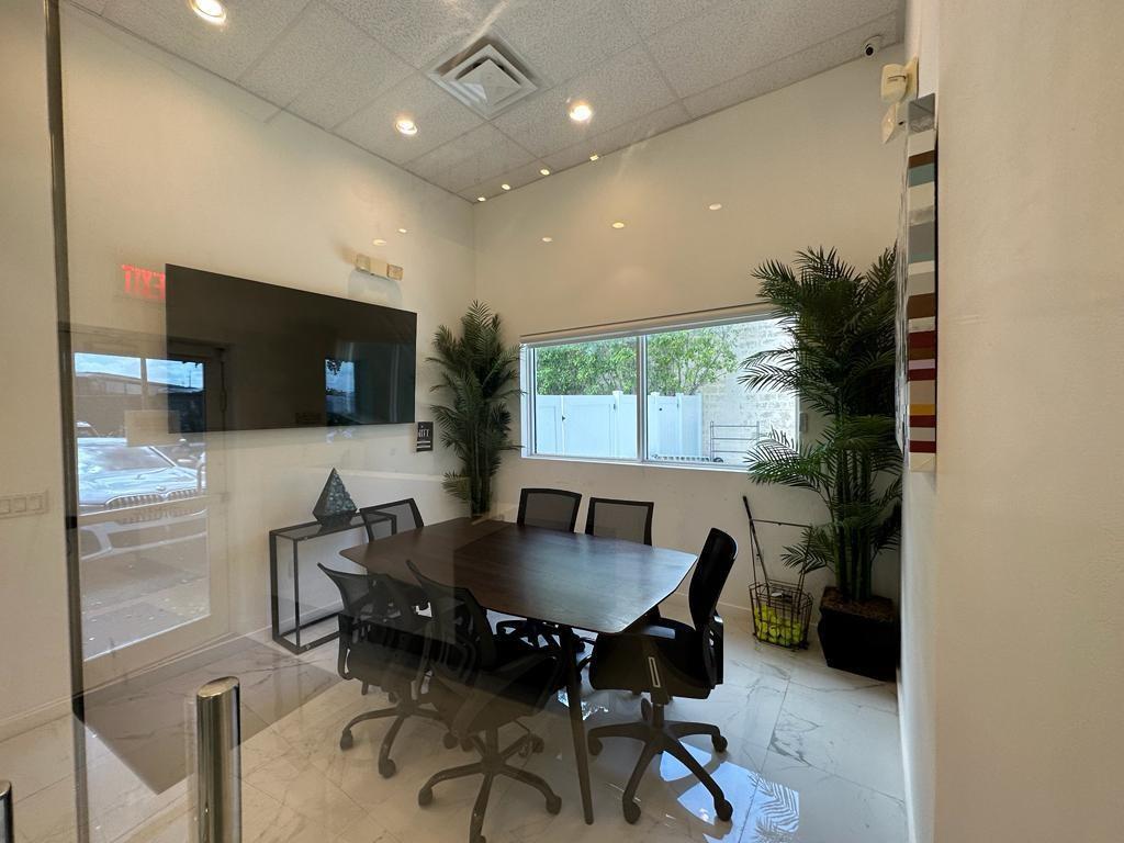 A modern conference room features a dark wood table, black chairs, and two potted plants — 425 NW 10th Terrace, Hallandale Beach FL 33009, HALLANDALE BEACH, FL