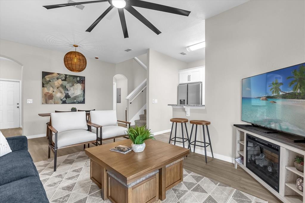A living room with a television, fireplace console, two armchairs, and a coffee table — 2020 CALABRIA AVENUE, DAVENPORT, FL