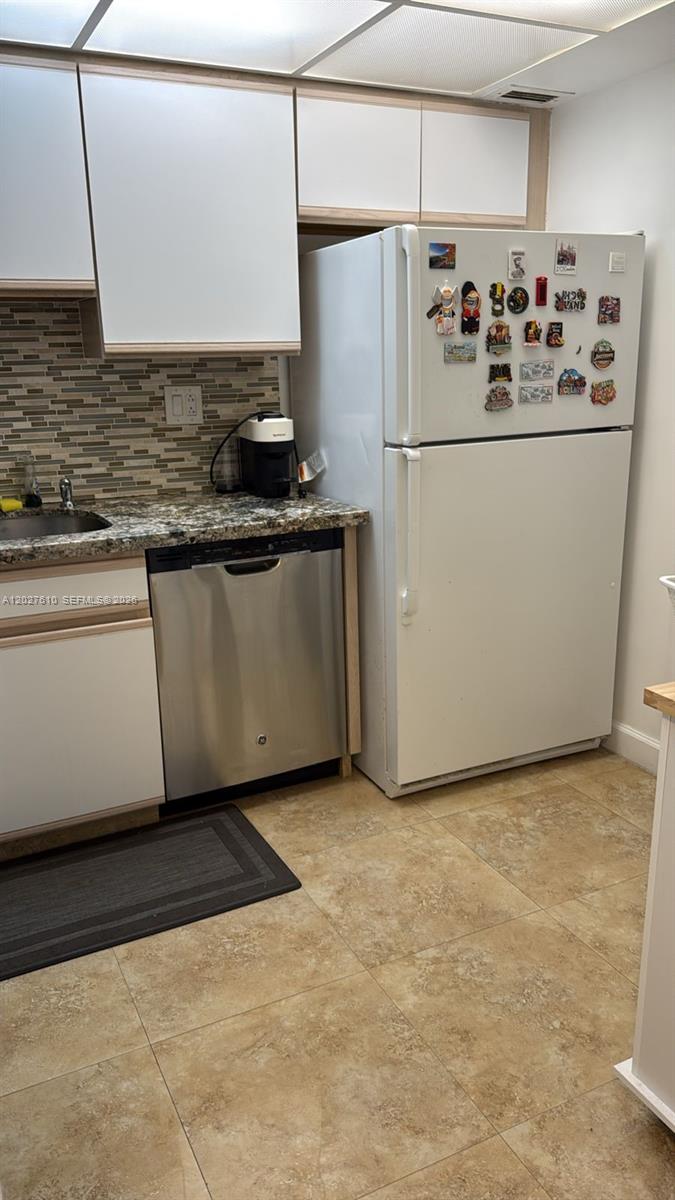 A kitchen features white cabinets, a stainless steel dishwasher, a white refrigerator, and tiled flooring — 2030 S Ocean Dr # 1111, Hallandale Beach FL 33009, HALLANDALE BEACH, FL