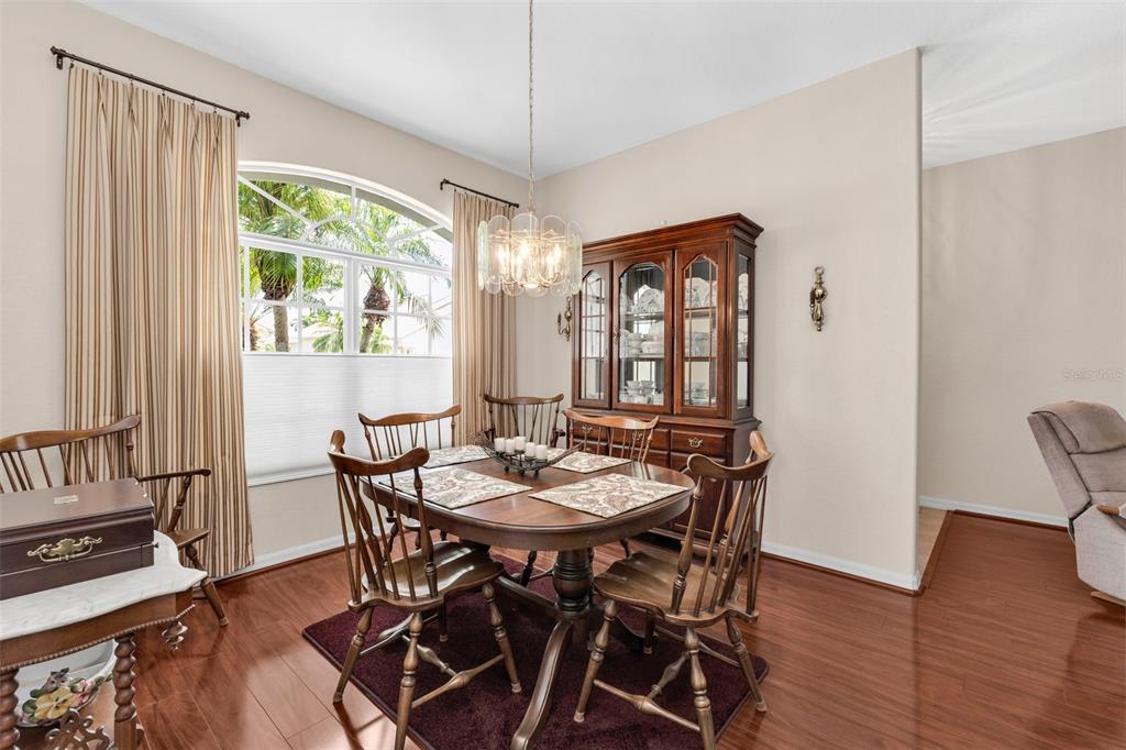A dining room features a wooden table and chairs, a hutch, and a large arched window — 24615 BUCKINGHAM WAY, PUNTA GORDA, FL