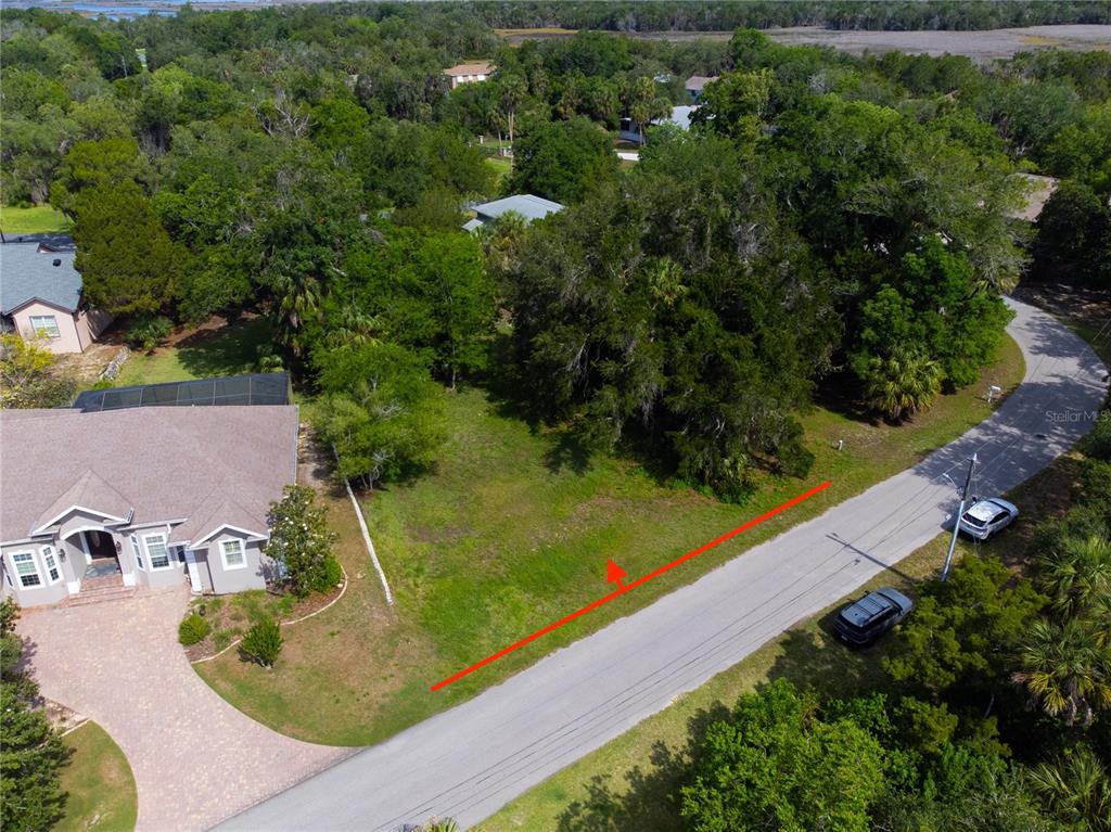 An aerial view shows a vacant, grassy residential lot situated between a house and a road — 4648 S GATOR LOOP, HOMOSASSA, FL
