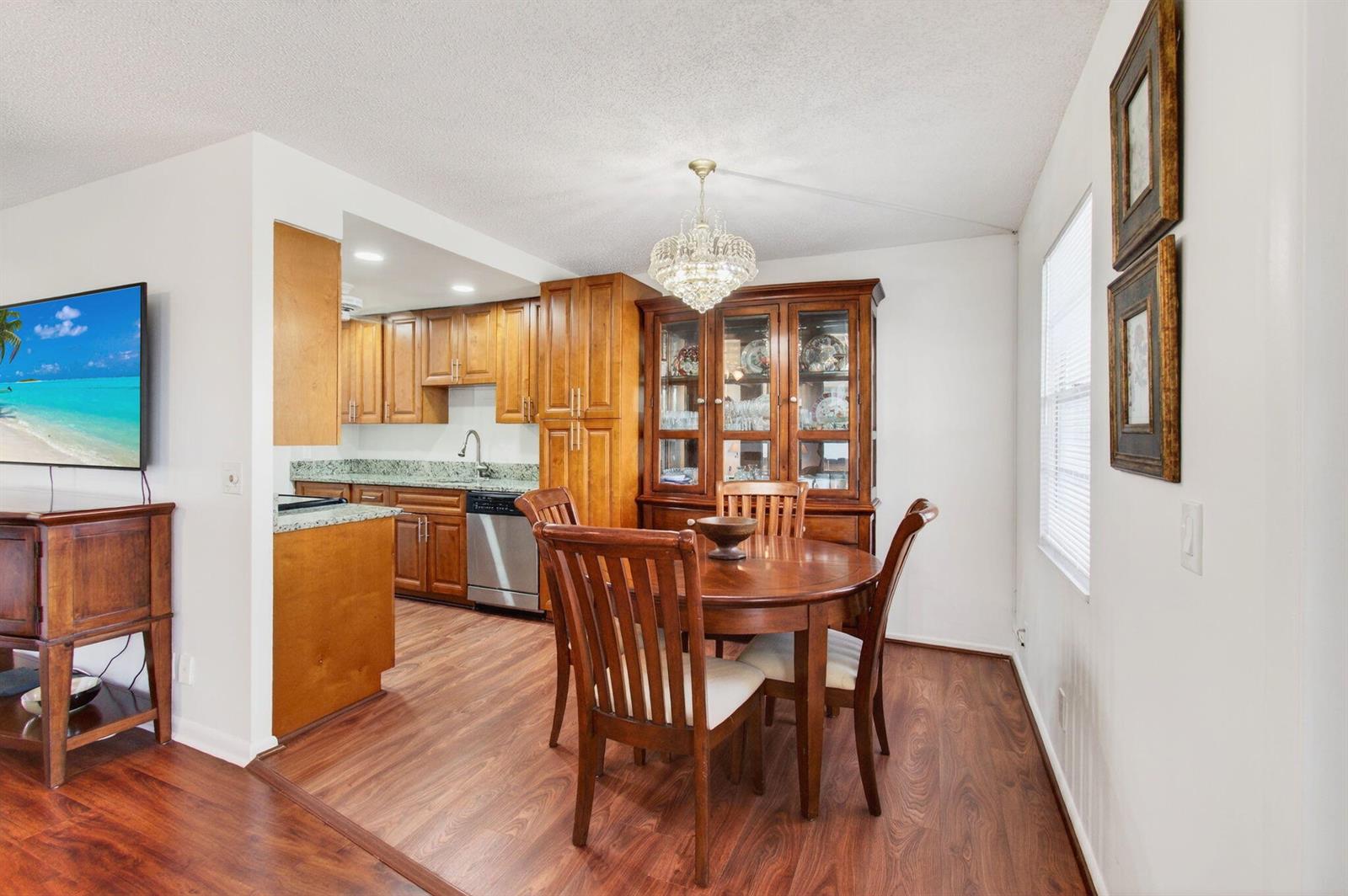 A dining area with a wooden table and hutch adjacent to a kitchen with cabinets — 2035 Cornwall B, Boca Raton FL 33434, BOCA RATON, FL