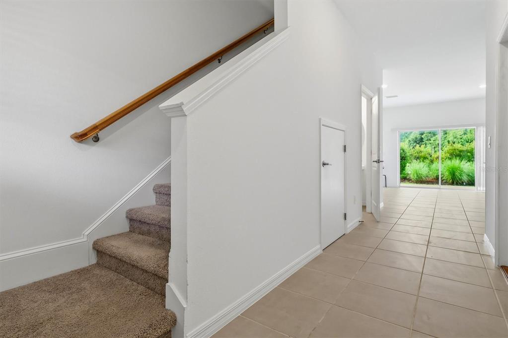 A staircase with carpeted steps and a wooden handrail leads to an upper floor — 34202 POLACCA LANE, WESLEY CHAPEL, FL