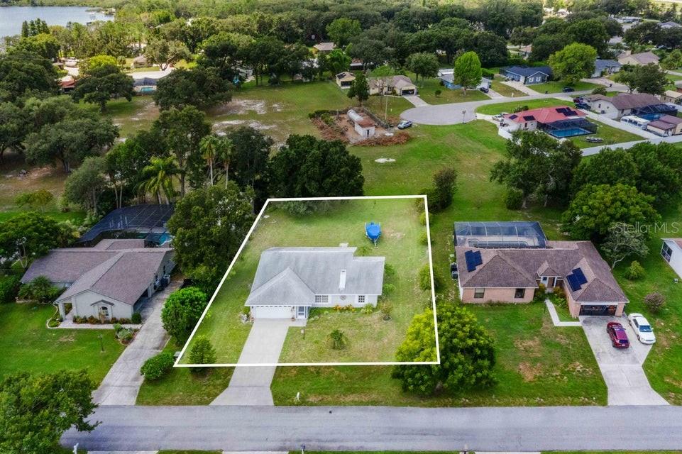 An aerial view shows a single-story house with a white outline on its property lot — 910 LIBERTY LANE, AUBURNDALE, FL