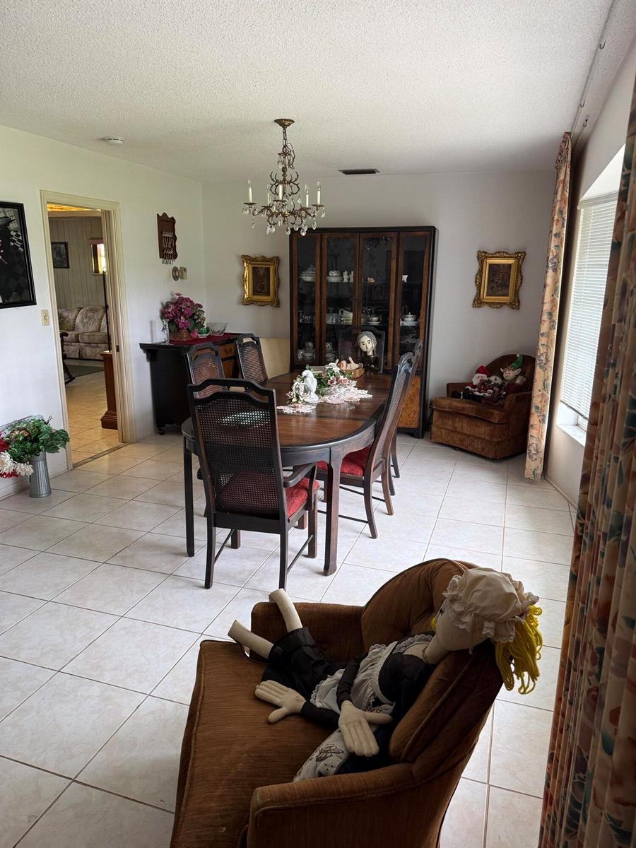 A dining room features a wooden table, chairs, a hutch, and tile flooring — 626 S Crescent Drive, Hollywood FL 33021, HOLLYWOOD, FL