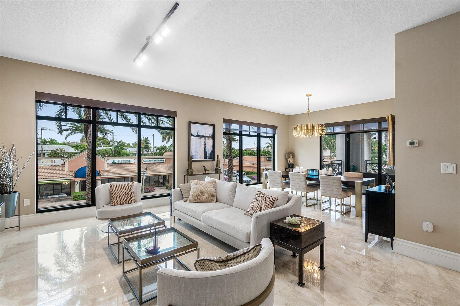 A bright living and dining area features beige walls, marble floors, and large floor-to-ceiling windows — 200 E Palmetto Park Road # 22, Boca Raton FL 33432, BOCA RATON, FL