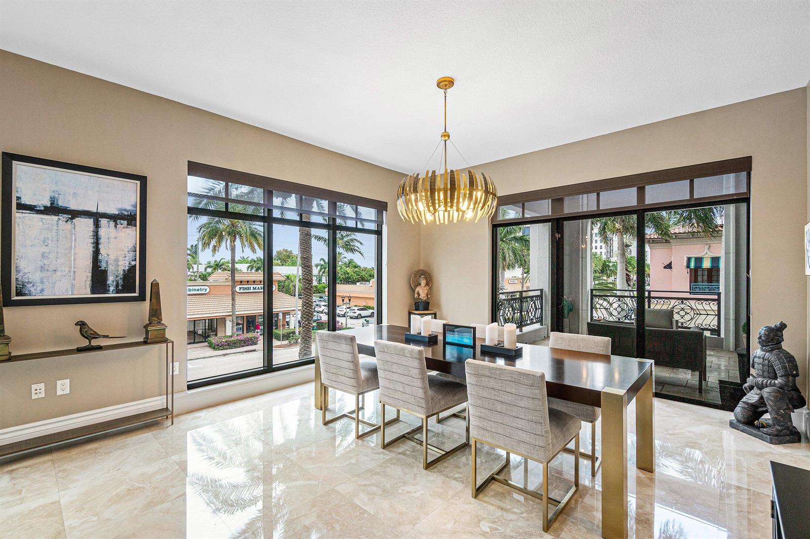 A dining room features a dark wood table, upholstered chairs, a gold chandelier, and balcony access — 200 E Palmetto Park Road # 22, Boca Raton FL 33432, BOCA RATON, FL