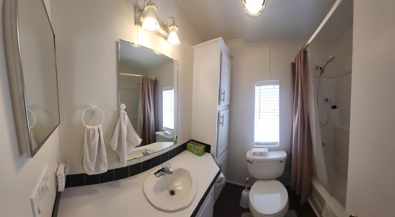 A bathroom features a white vanity, a mirror, a toilet, and a shower-tub combination — 900 Juno Ocean Walk # 37, Juno Beach FL 33408, JUNO BEACH, FL