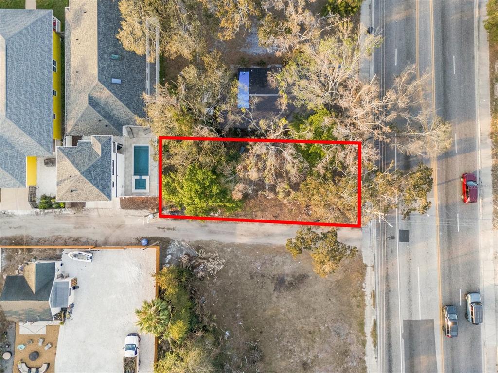 An aerial view shows a rectangular vacant lot bordered by trees, a road, and buildings — 28TH STREET S, ST PETERSBURG, FL