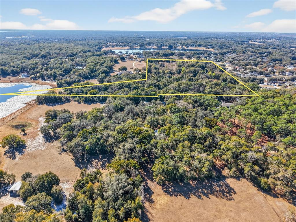 An aerial view shows a large, wooded plot of land outlined in yellow — MYRTLE LAKE AVENUE, FRUITLAND PARK, FL