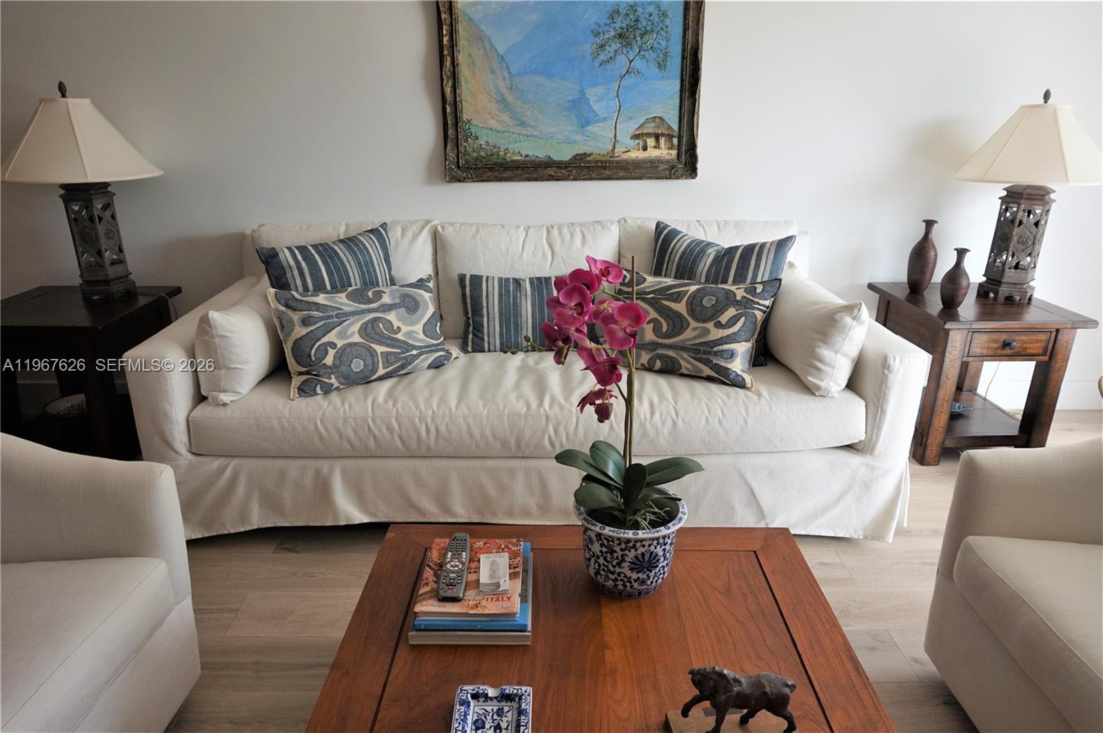 A living room features a white sofa with patterned pillows, a wooden coffee table, and lamps — 210 Sea View Dr # 408, Key Biscayne FL 33149, KEY BISCAYNE, FL