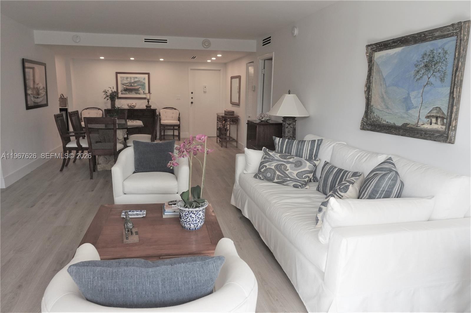 A living room features a white sofa, two armchairs, a wooden coffee table, and dining area — 210 Sea View Dr # 408, Key Biscayne FL 33149, KEY BISCAYNE, FL