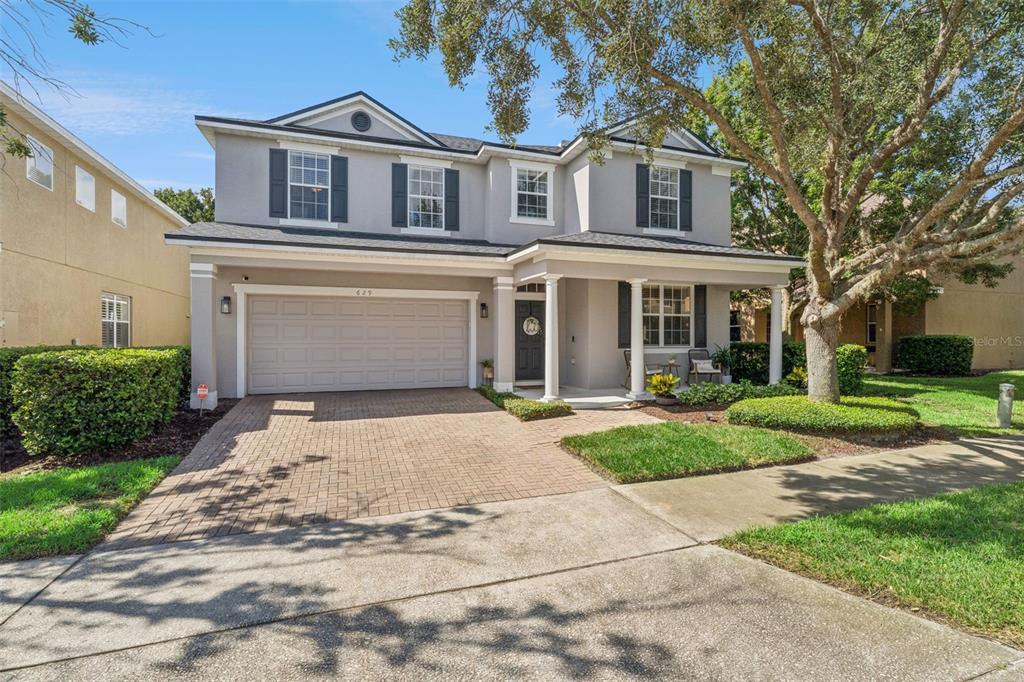 A two-story suburban house features a paved driveway, a two-car garage, and a covered porch — 629 LEGACY PARK DRIVE, CASSELBERRY, FL