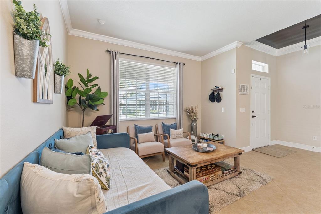 A living room features a blue sofa, two armchairs, a wooden coffee table, and tile flooring — 629 LEGACY PARK DRIVE, CASSELBERRY, FL