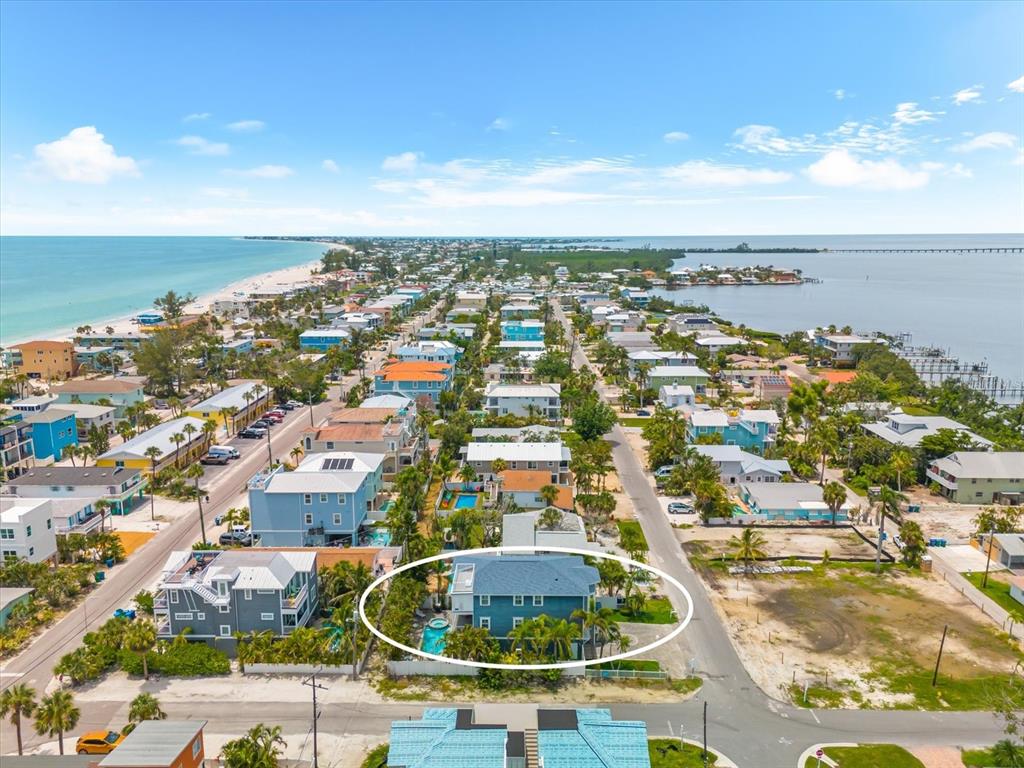 An aerial view shows a blue house with a pool in a coastal neighborhood — 2300 AVENUE B, BRADENTON BEACH, FL
