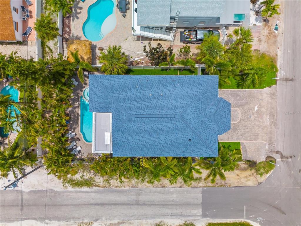 An aerial view shows a house with a blue roof, a swimming pool, and palm trees — 2300 AVENUE B, BRADENTON BEACH, FL