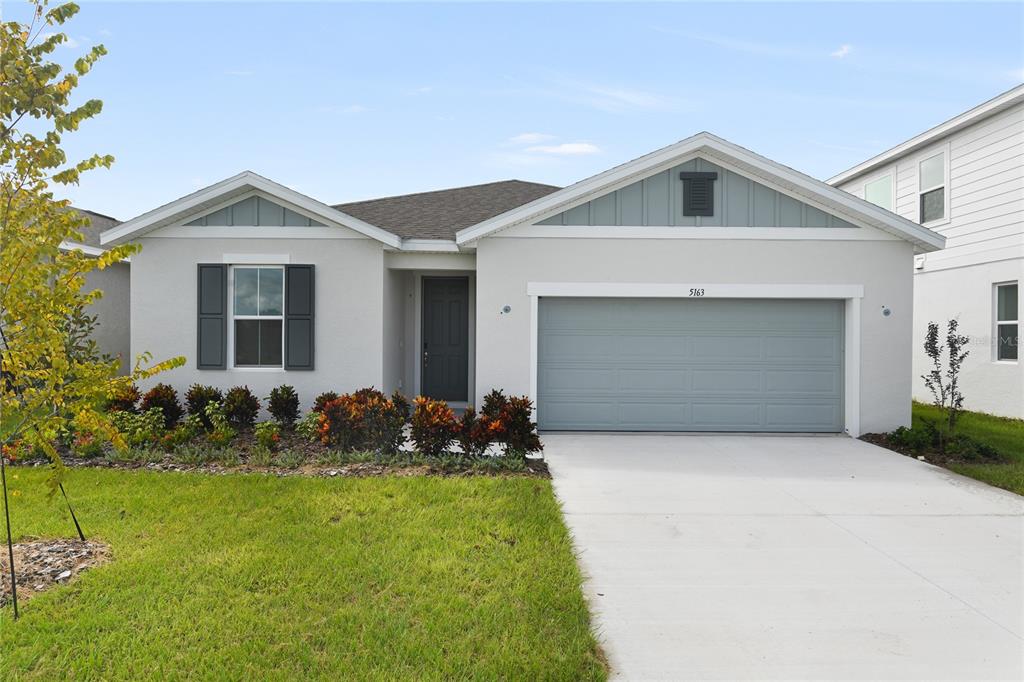A single-story house with a light gray exterior, a two-car garage, and a front lawn — 5163 KINSLEY DRIVE, WINTER HAVEN, FL
