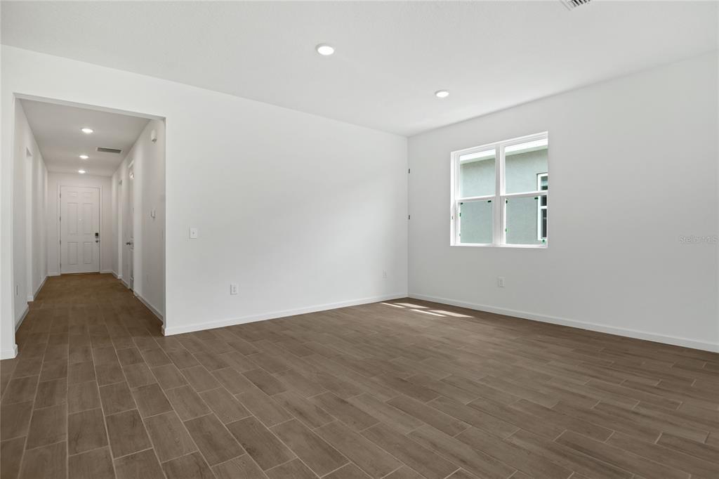 An empty room with white walls, recessed lighting, and wood-look tile flooring — 5163 KINSLEY DRIVE, WINTER HAVEN, FL
