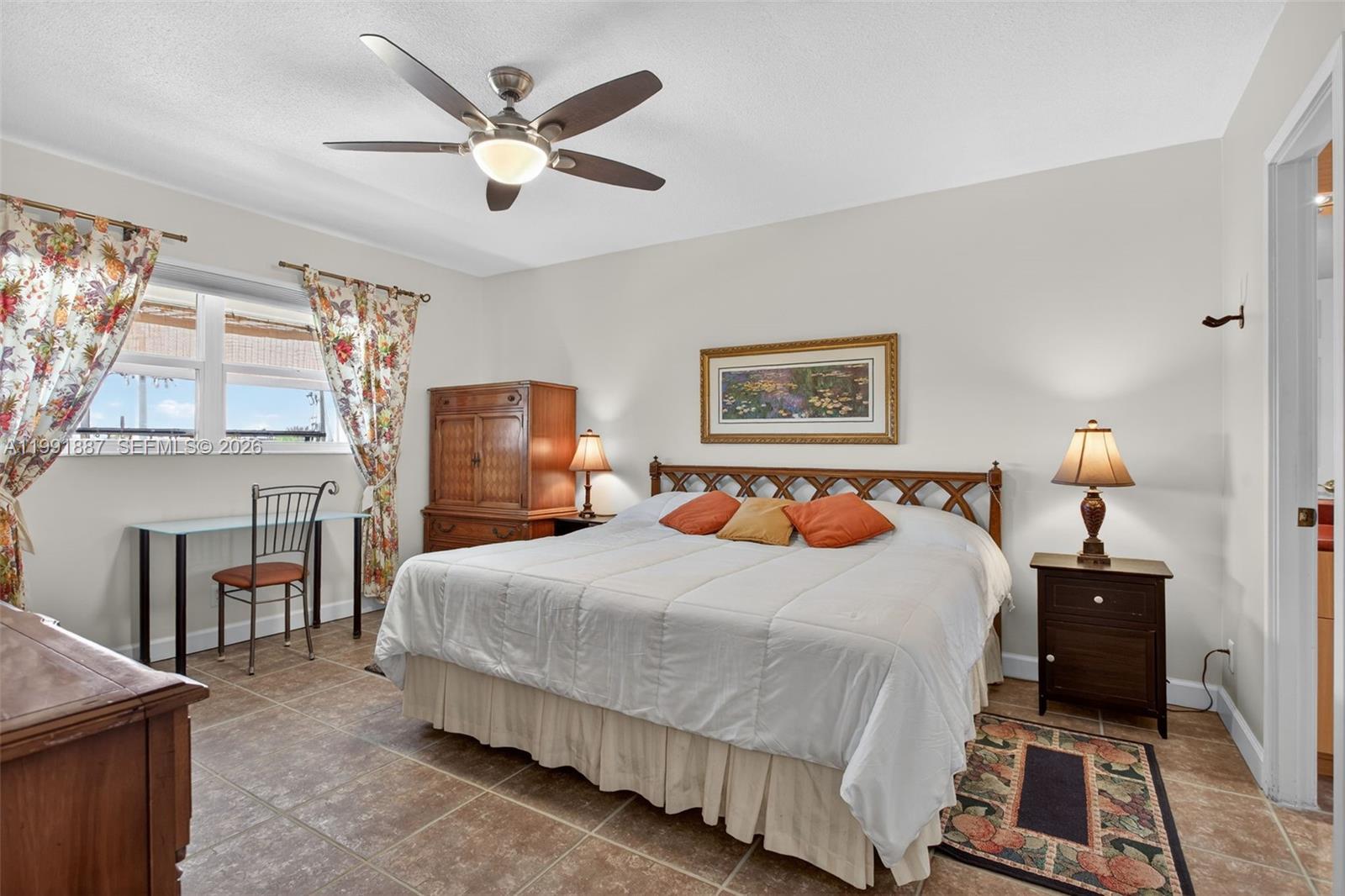 A bedroom features a king bed, tile flooring, a ceiling fan, and a small desk — 4299 NW 16th St # 310, Lauderhill FL 33313, LAUDERHILL, FL