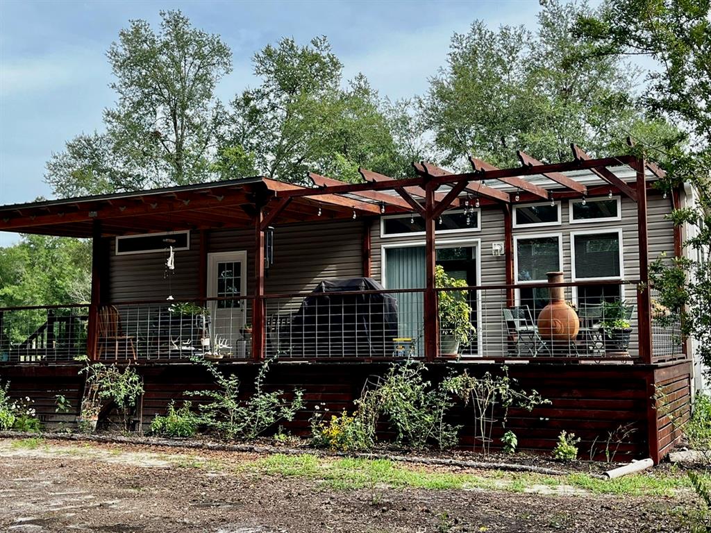 A mobile home with a large wooden deck, pergola, and wire railing sits outdoors — 3369 NE 53RD TERRACE, HIGH SPRINGS, FL