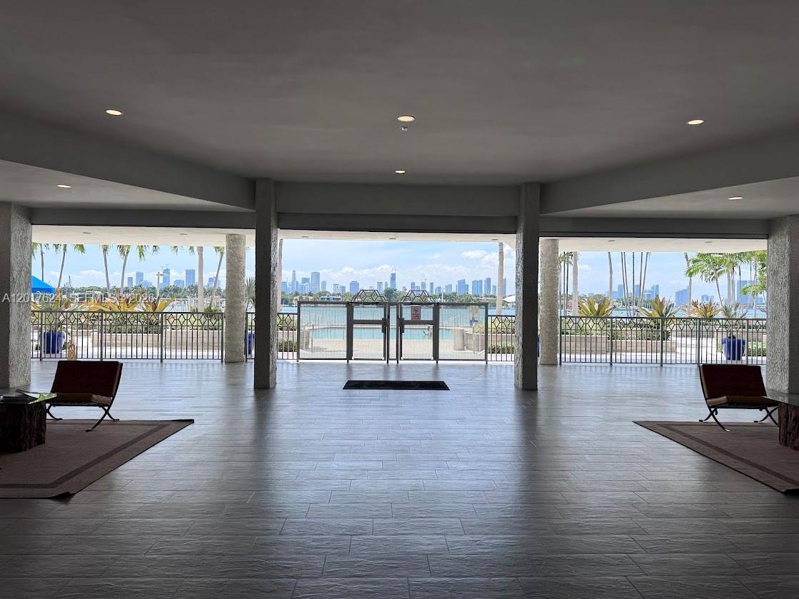 A spacious, tiled lobby features two chairs and a wide view of a city skyline — 800 West Ave # 441, Miami Beach FL 33139, MIAMI BEACH, FL