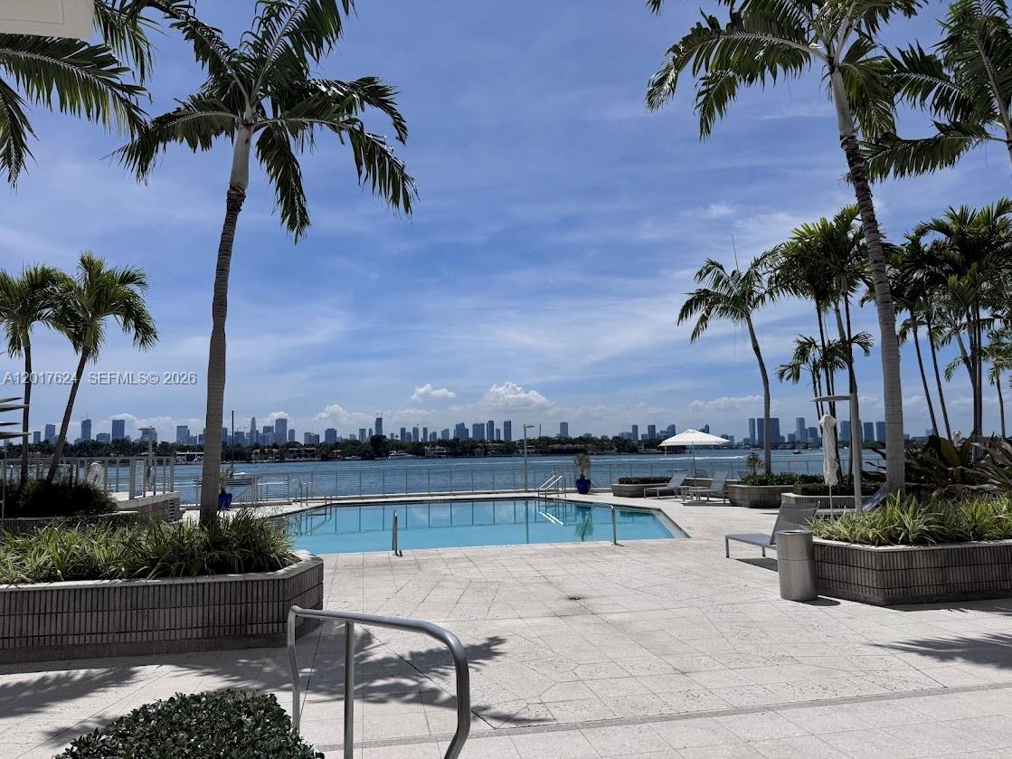 A swimming pool overlooks a bay with a city skyline in the background — 800 West Ave # 441, Miami Beach FL 33139, MIAMI BEACH, FL