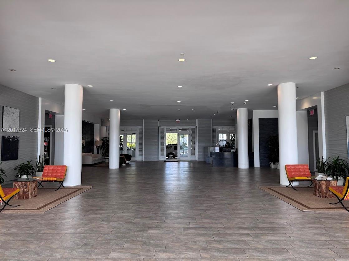 A spacious lobby features large white columns, tiled floors, and orange seating areas — 800 West Ave # 441, Miami Beach FL 33139, MIAMI BEACH, FL