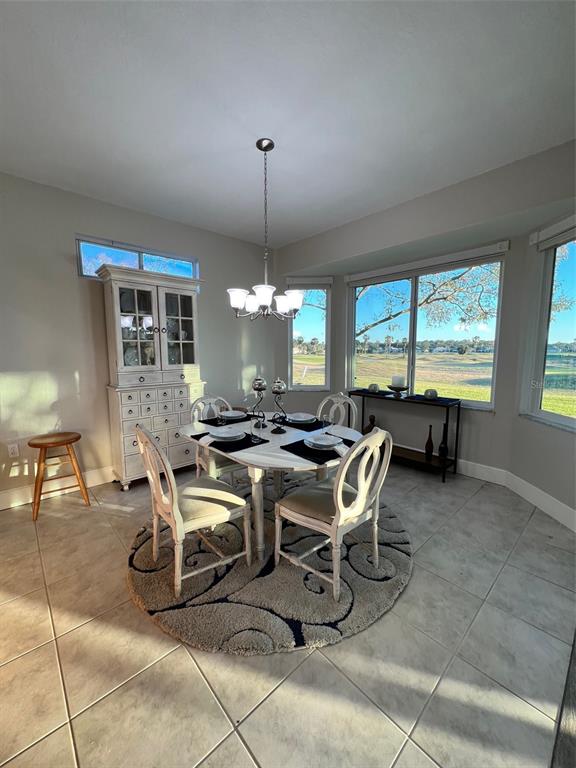 A dining area features a white hutch, a round table with four chairs, and large windows — 9570 SE 136TH PLACE, SUMMERFIELD, FL