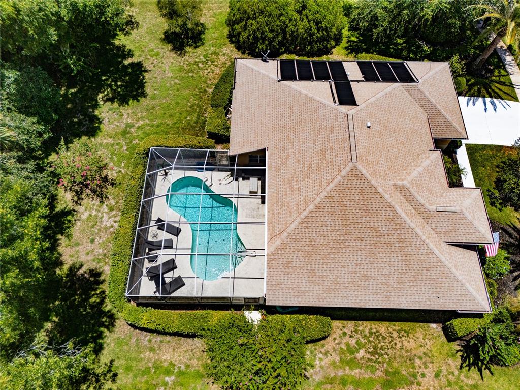 An aerial view shows a house with a shingled roof, solar panels, and a screened pool — 5 FAIRFAX COURT, PALM COAST, FL