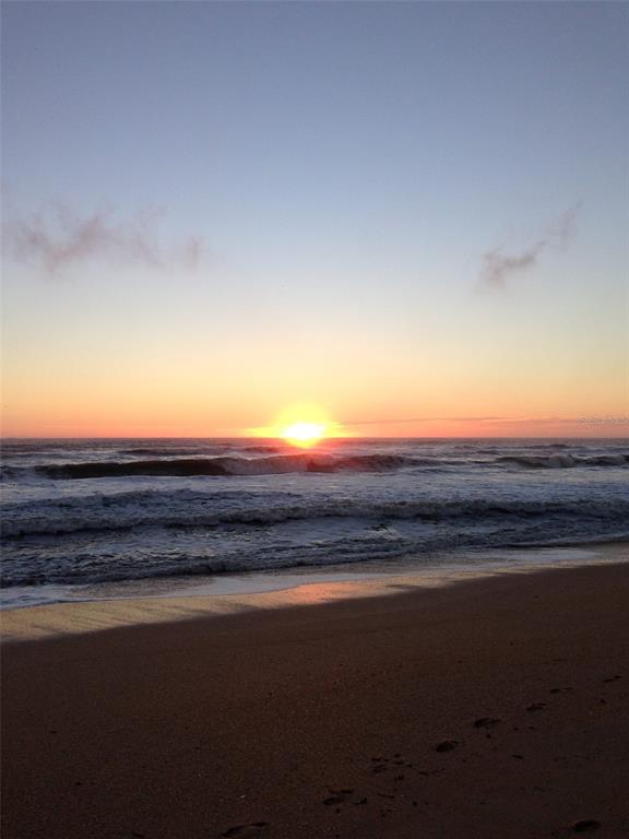A view of the ocean at sunrise with waves crashing onto a sandy beach — 5 FAIRFAX COURT, PALM COAST, FL
