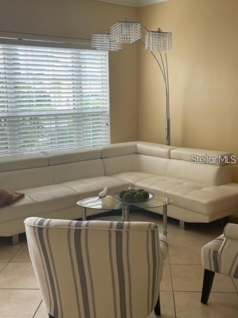 A living room features a white sectional sofa, a glass coffee table, and a floor lamp — 3537 MOSS POINTE PLACE, LAKE MARY, FL