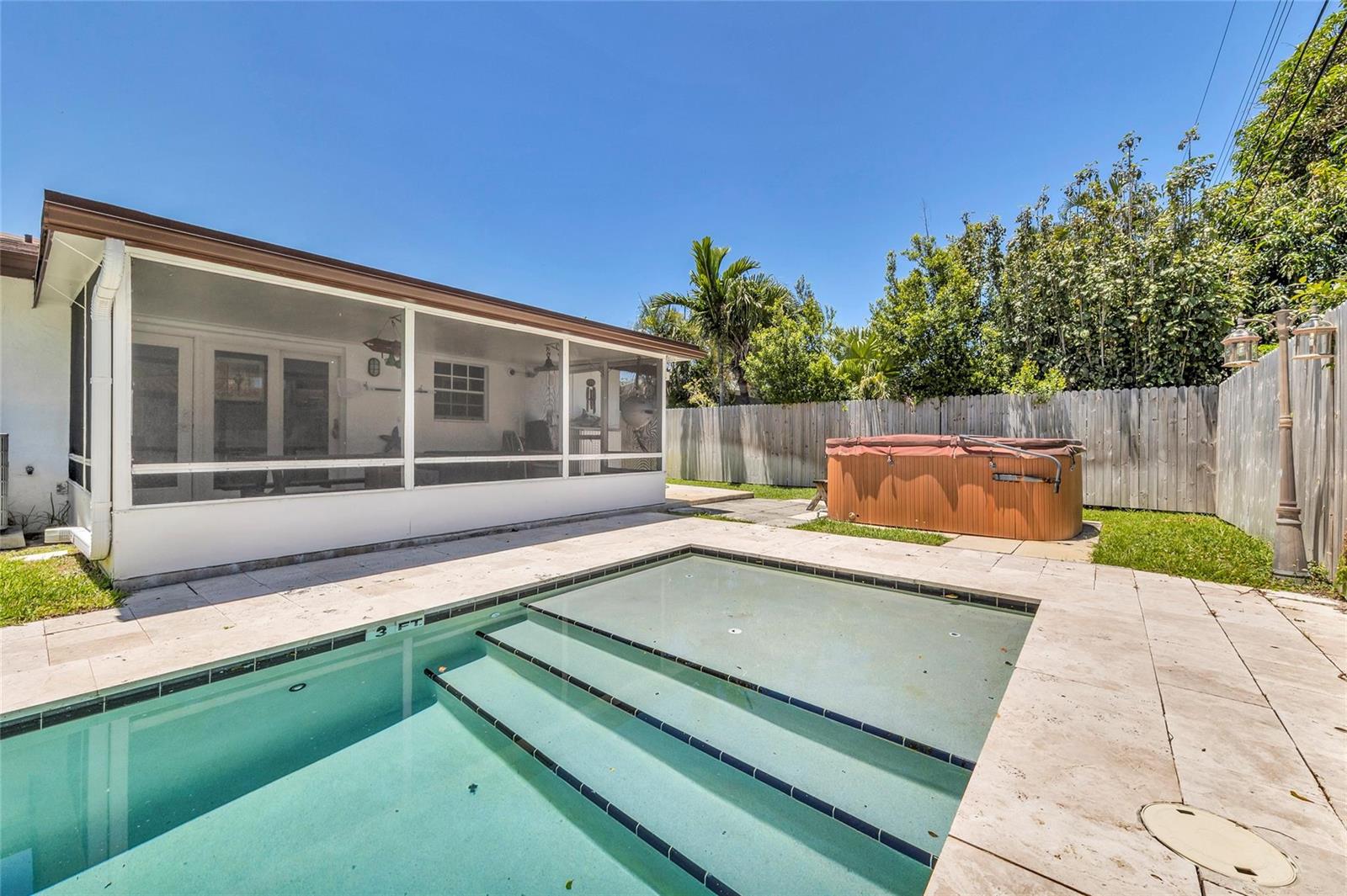 A backyard features a swimming pool with steps, a covered patio, and a hot tub — 3213 Dover Road, Pompano Beach FL 33062, POMPANO BEACH, FL