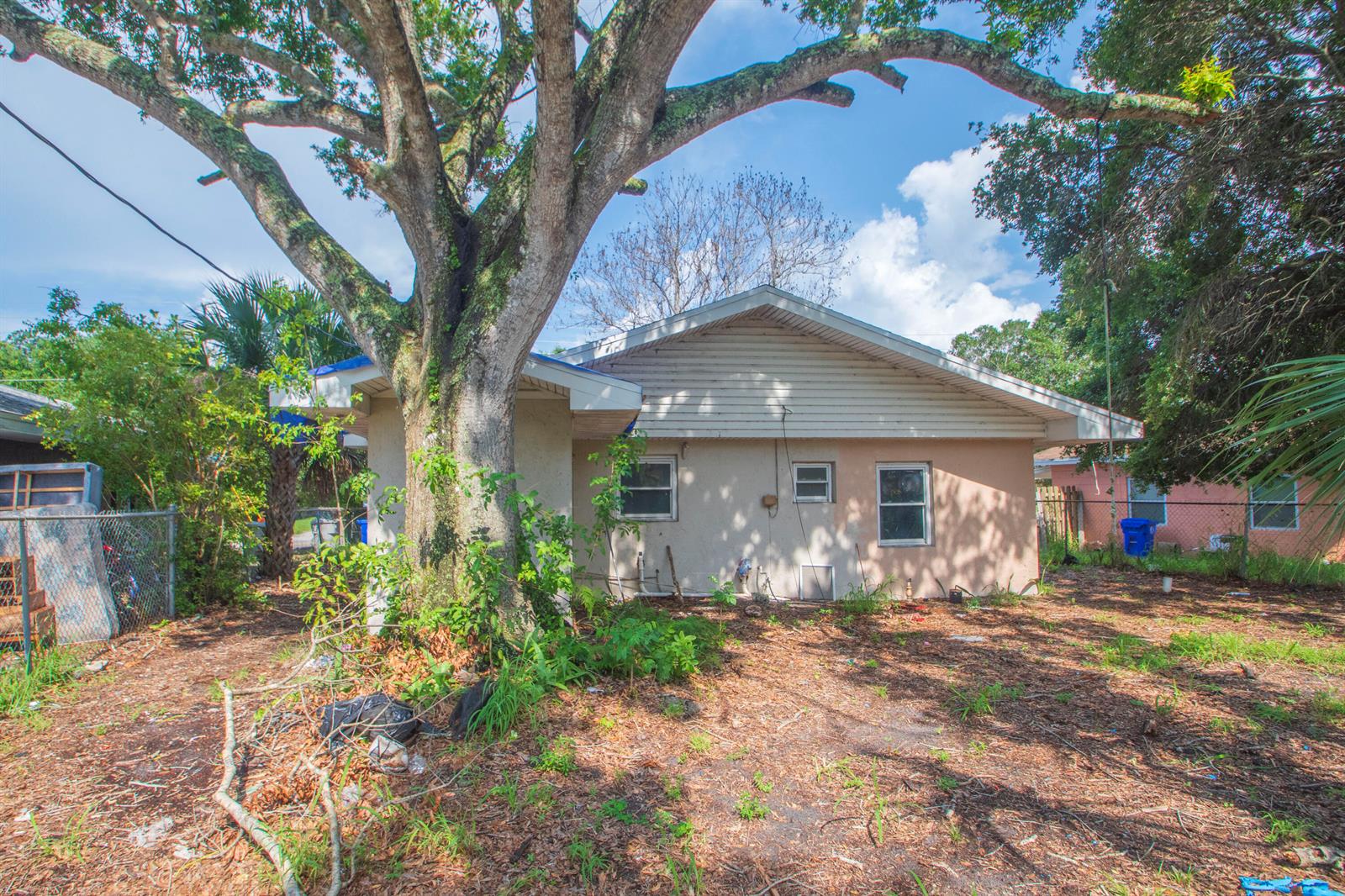The exterior of a single-story house with a large tree in the front yard — 4721 28th Court, Vero Beach FL 32967, VERO BEACH, FL