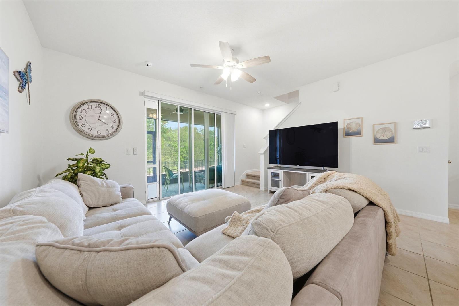 A living room features a large sectional sofa, a television, and sliding glass patio doors — 986 Lido Drive, FL 34737, FL