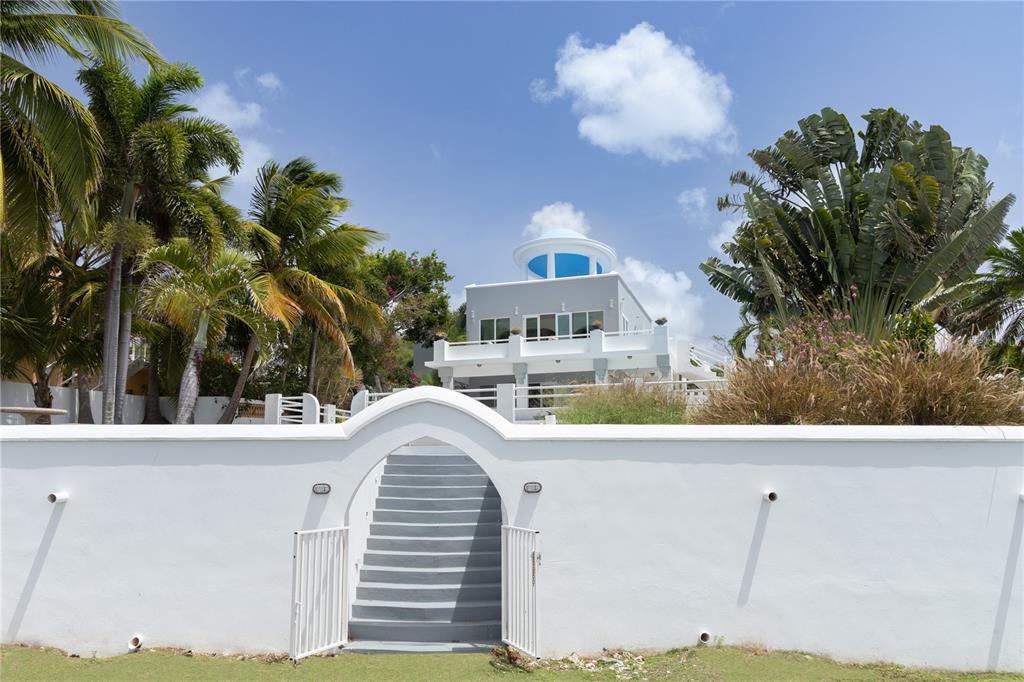 A white wall with an arched gate and stairs leads to a multi-level house — 411 BRAVOS DE BOSTON, VIEQUES, PR