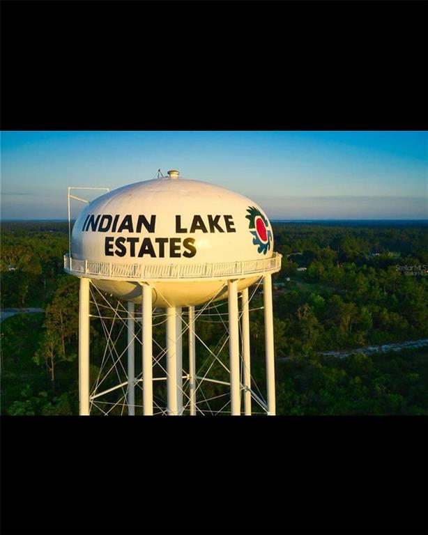 A white water tower with the text Indian Lake Estates stands above a forested landscape — 1014 JAPONICA DRIVE, INDIAN LAKE ESTATES, FL