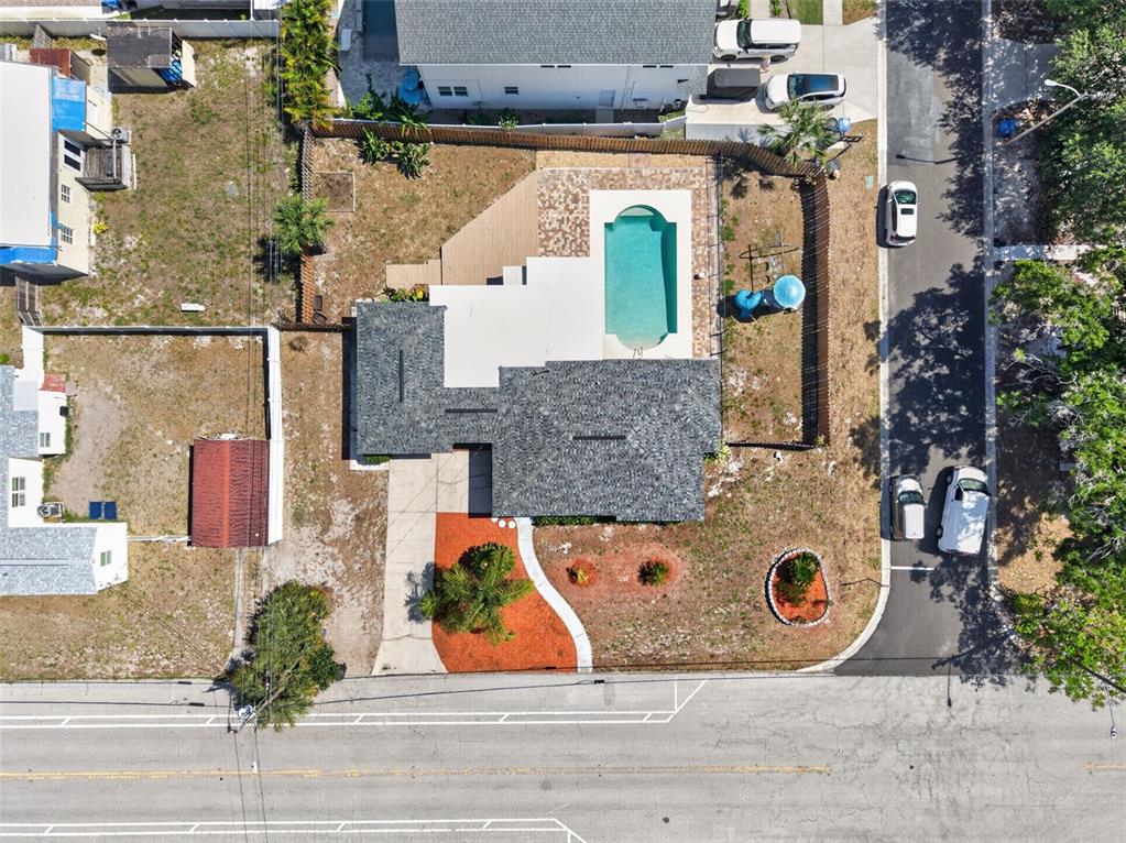 An aerial view shows a house with a shingled roof, swimming pool, and paved driveway — 1674 34TH AVENUE N, ST PETERSBURG, FL