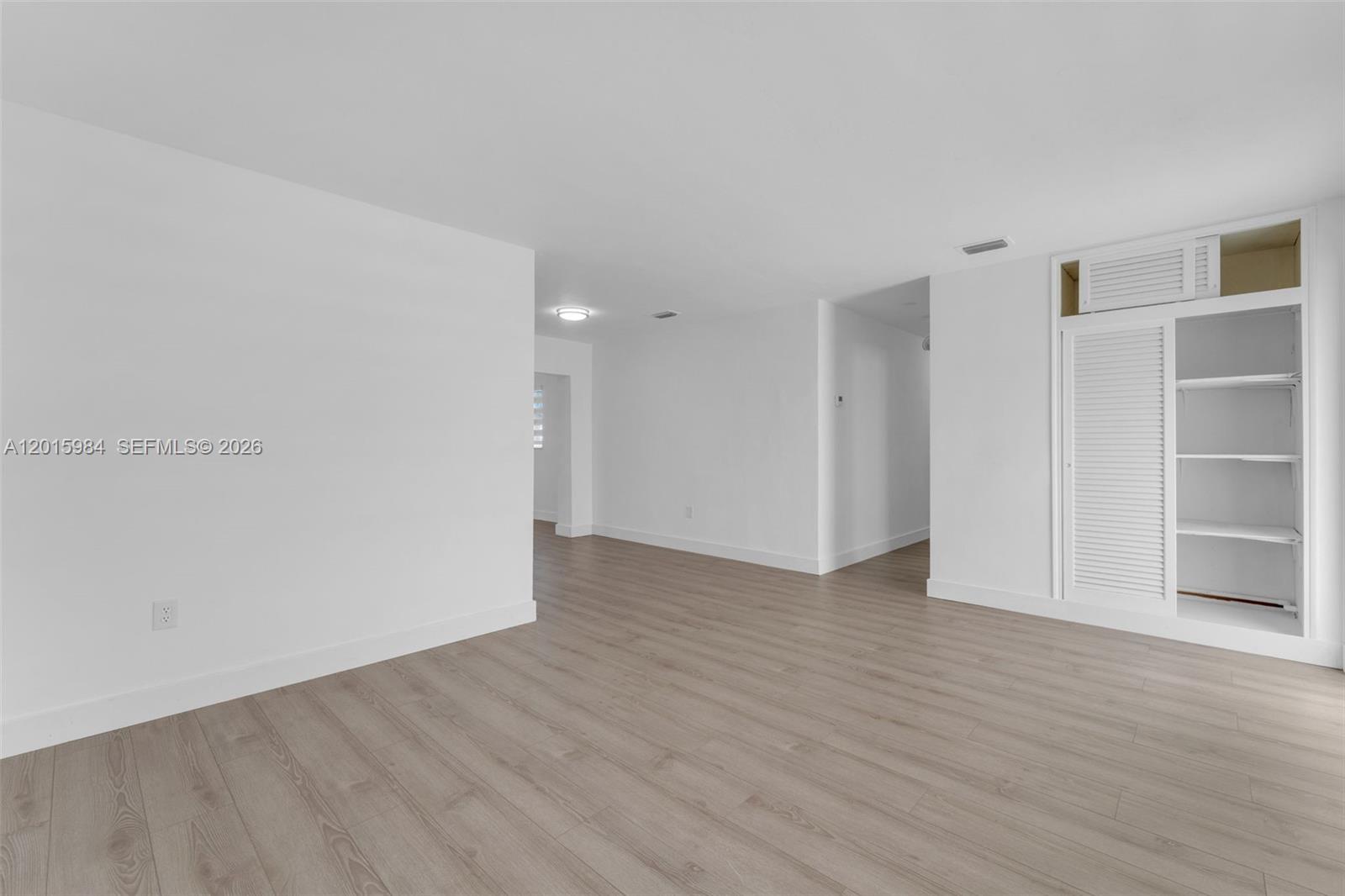 An empty room features white walls, light wood-look flooring, and a built-in storage closet — 4211 SW 97th Pl, Miami FL 33165, MIAMI, FL