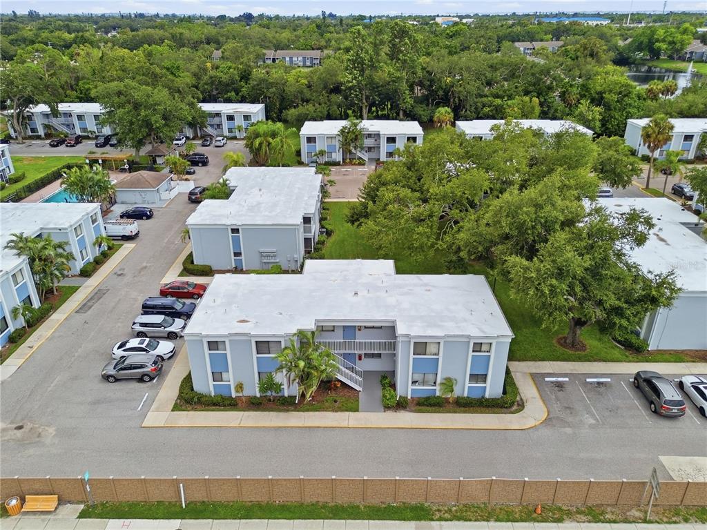 An aerial view shows several light blue apartment buildings surrounded by trees and parking lots — 5310 26TH STREET W UNIT 804, BRADENTON, FL
