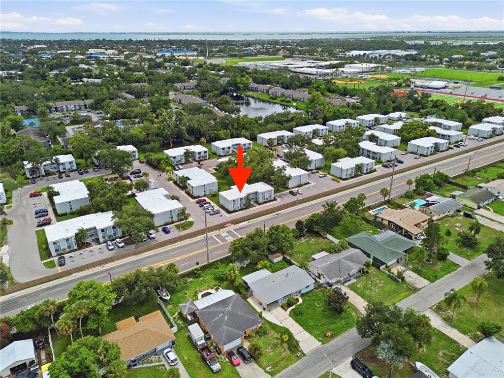 An aerial view shows a multi-unit apartment complex with a red arrow pointing to one building — 5310 26TH STREET W UNIT 804, BRADENTON, FL