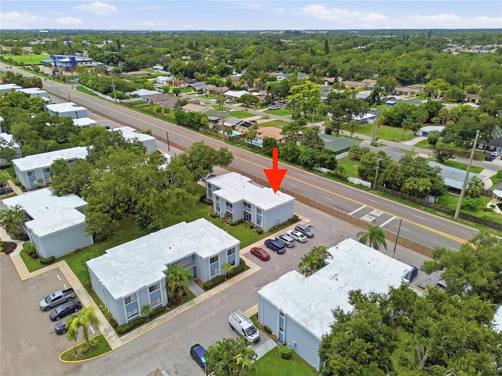 An aerial view shows a multi-unit apartment building with a flat roof next to a road — 5310 26TH STREET W UNIT 804, BRADENTON, FL