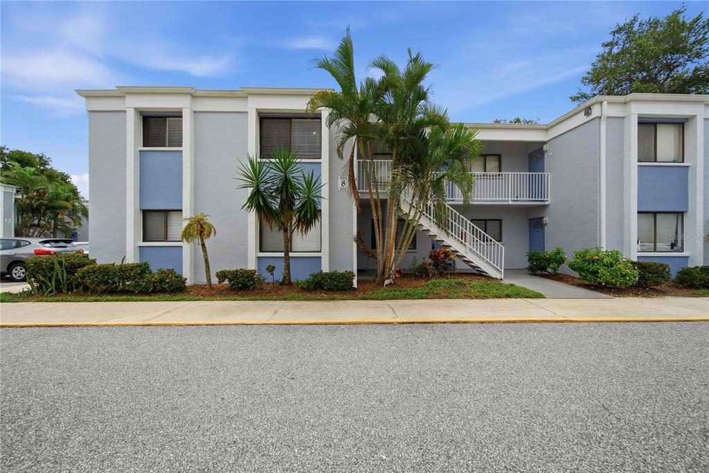 A two-story apartment building with light gray stucco, blue accents, and an exterior staircase — 5310 26TH STREET W UNIT 804, BRADENTON, FL
