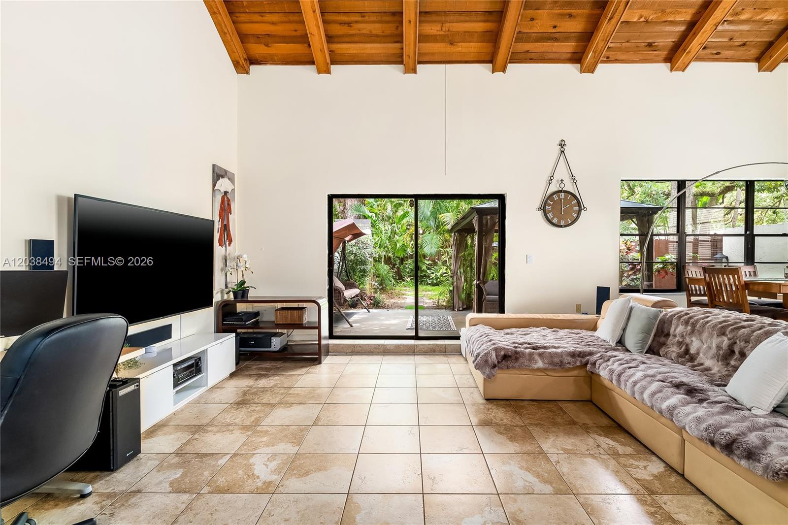 A living room features a vaulted wood-beam ceiling, tile floors, and a sliding glass door — 3340 Oak Dr, Hollywood FL 33021, HOLLYWOOD, FL