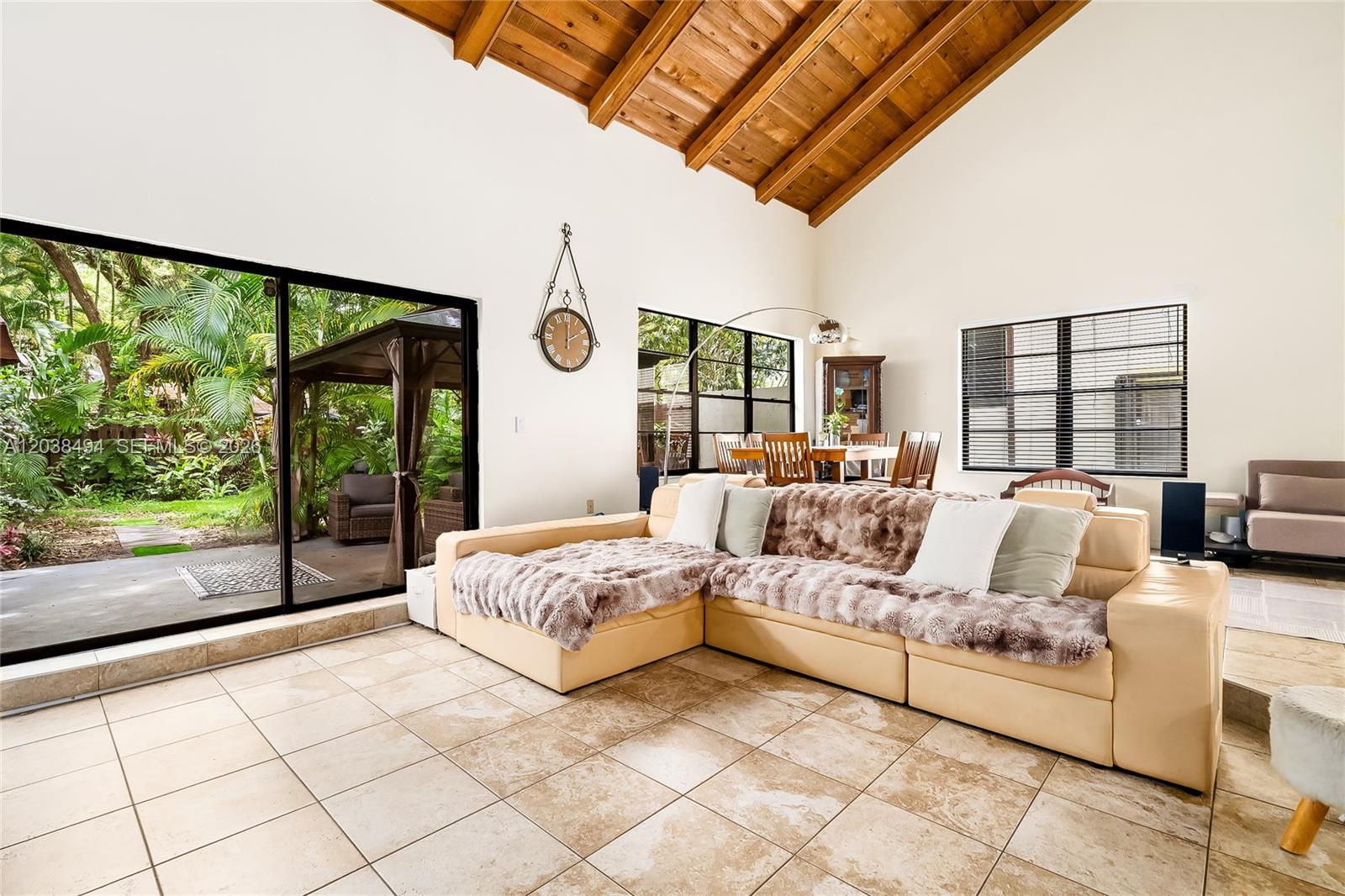 A living room with a vaulted wood-beam ceiling, tile floors, and a large sectional sofa — 3340 Oak Dr, Hollywood FL 33021, HOLLYWOOD, FL