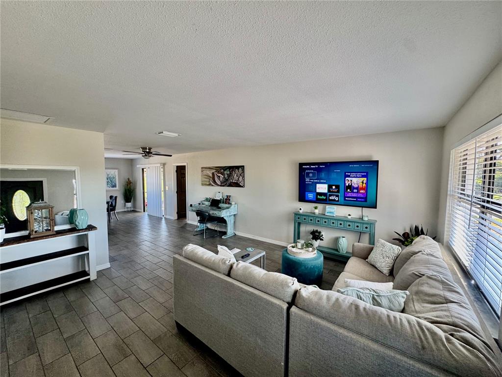 A living room features tile floors, a sectional sofa, a wall-mounted television, and a desk — 118 ROTONDA CIRCLE, ROTONDA WEST, FL