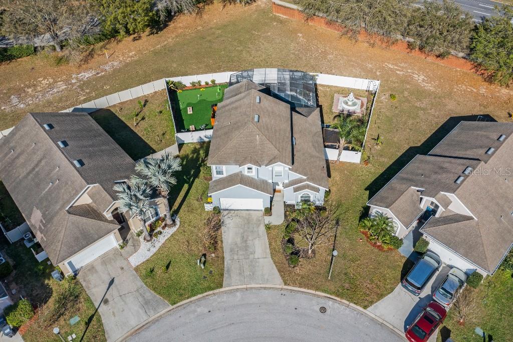 An aerial view shows three suburban houses with driveways and backyards in a cul-de-sac — 403 CORVINA DRIVE, DAVENPORT, FL