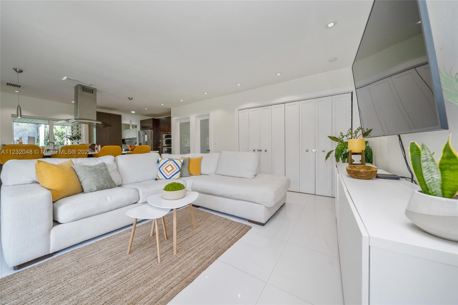 A modern living room features a white sectional sofa, a jute rug, and tile flooring — 7544 SW 78th Ter, Miami FL 33143, MIAMI, FL
