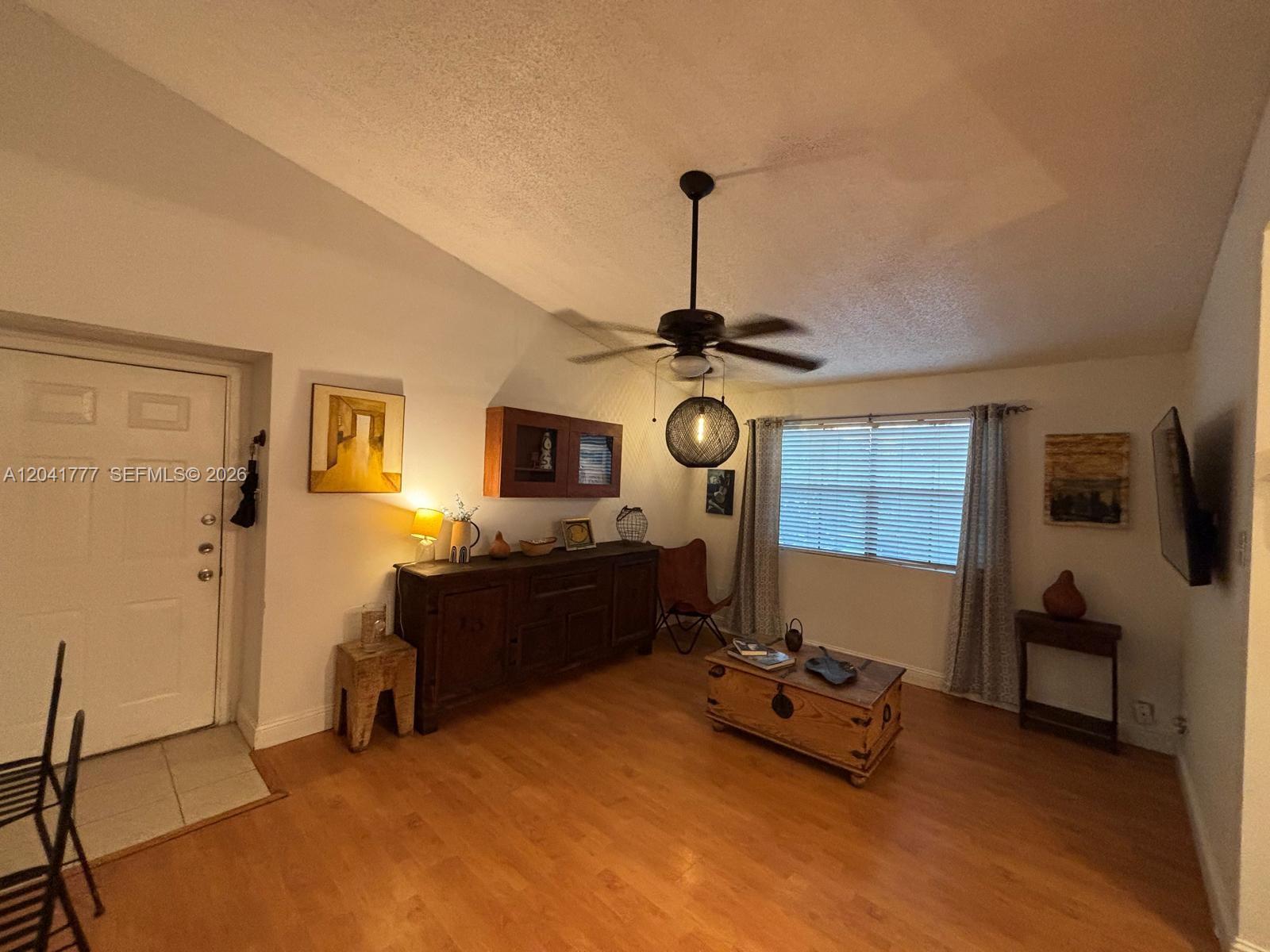 A living room features wood flooring, a ceiling fan, a wooden chest, and a sideboard — 15050 SW 103rd Ter # 7202, Miami FL 33196, MIAMI, FL